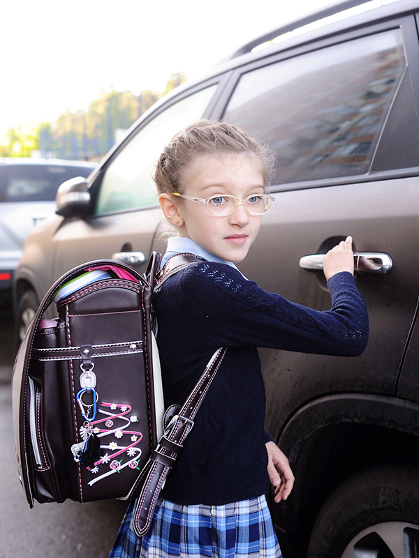 Girl with backpack getting into a car